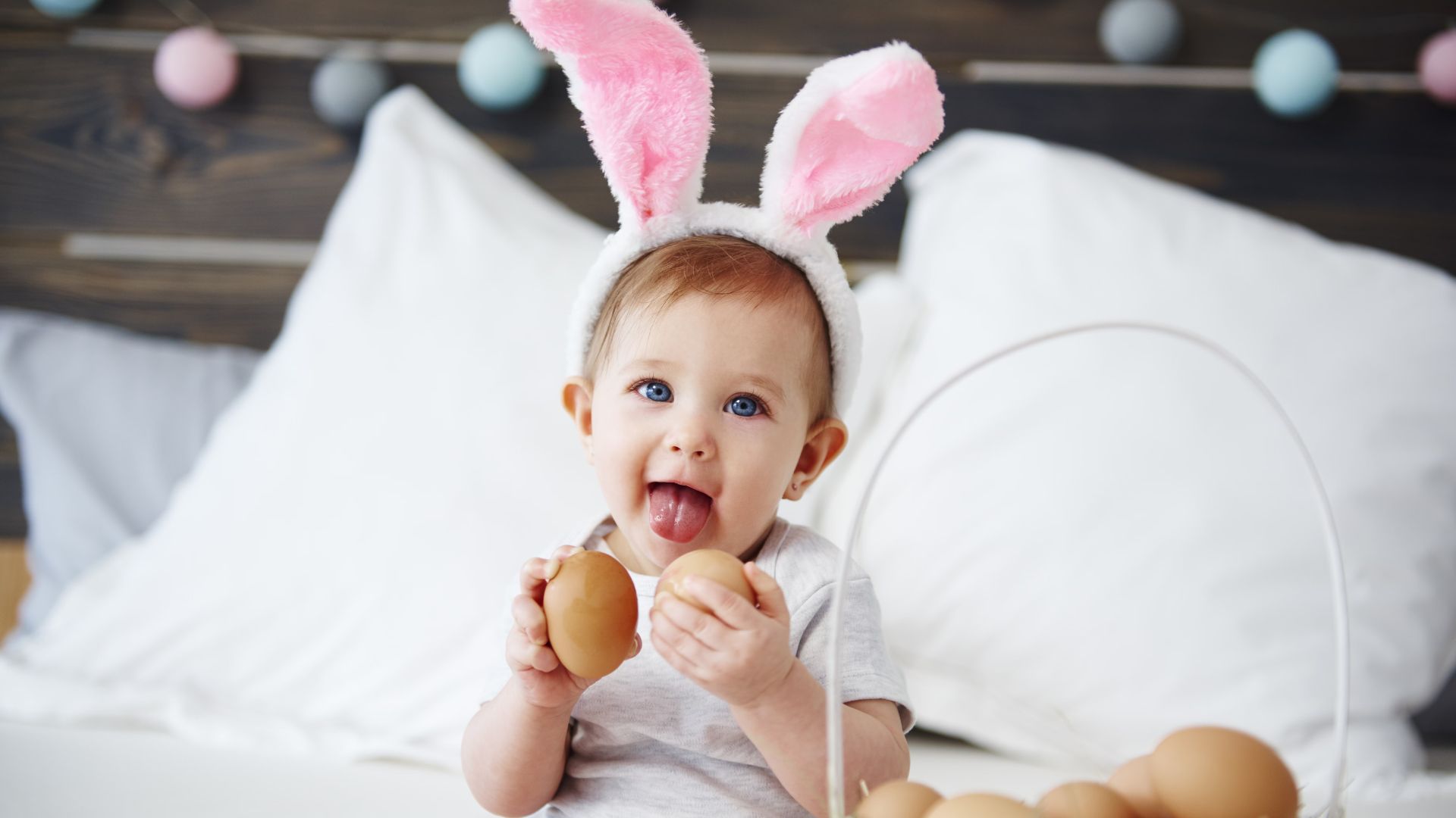 a baby girl holding two easter eggs