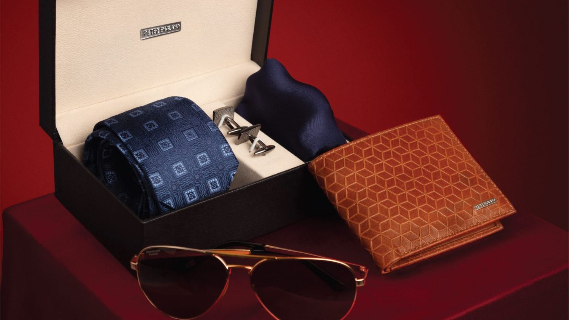 a wallet, shades, tie in a box showing the best gifts for men 