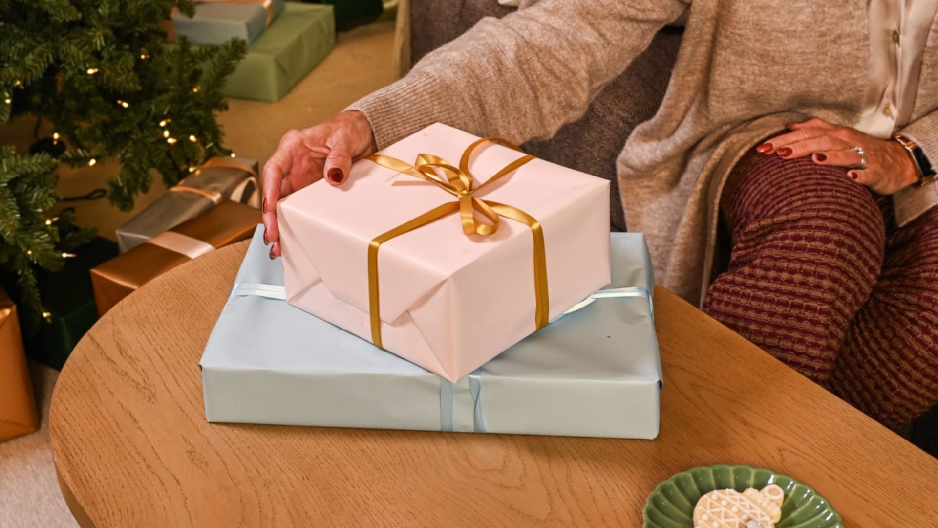 a women sitting while holding a box of gift showing one of the best gifts for men