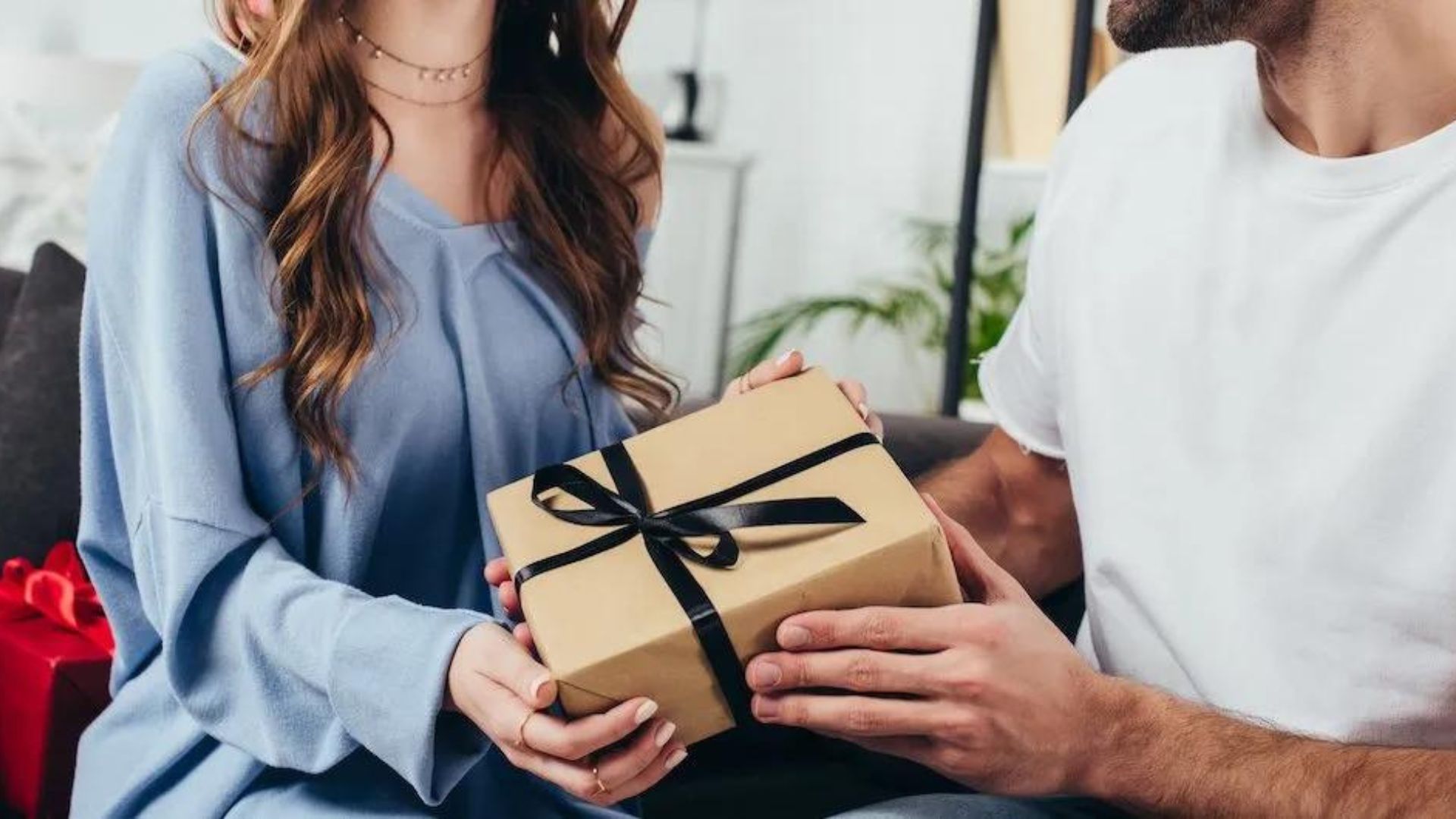 a man giving his wife a gift showing best gifts for women 